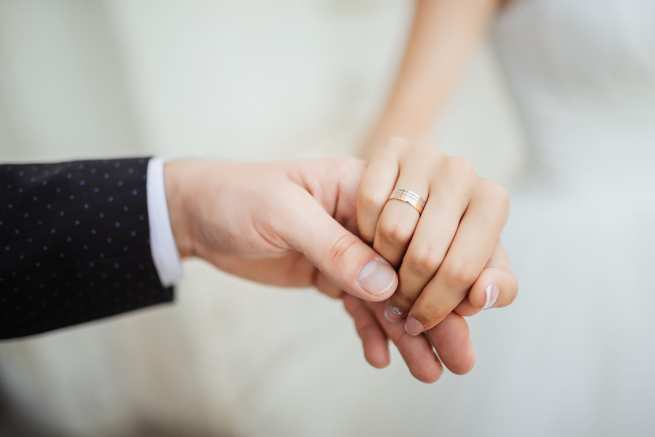 Nygift par der holder i hånd med vielsesringe på